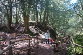 Elise and Micah hiking through the muddy Puzzlewood.